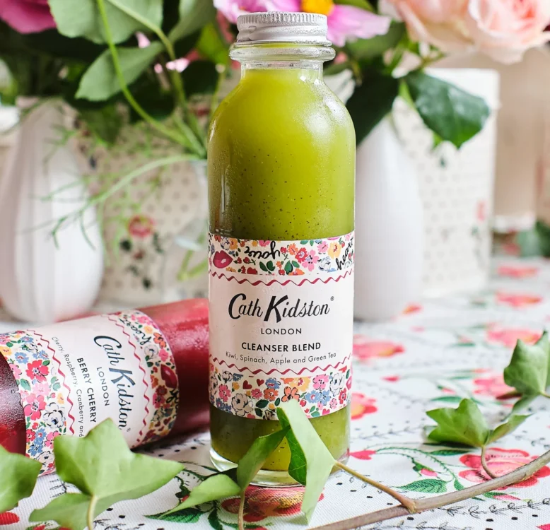 A bottle of Cath Kidston branded green smoothie surrounded by flowers