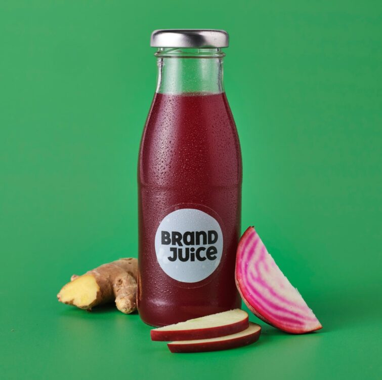 A bottle of purple juice on a green background