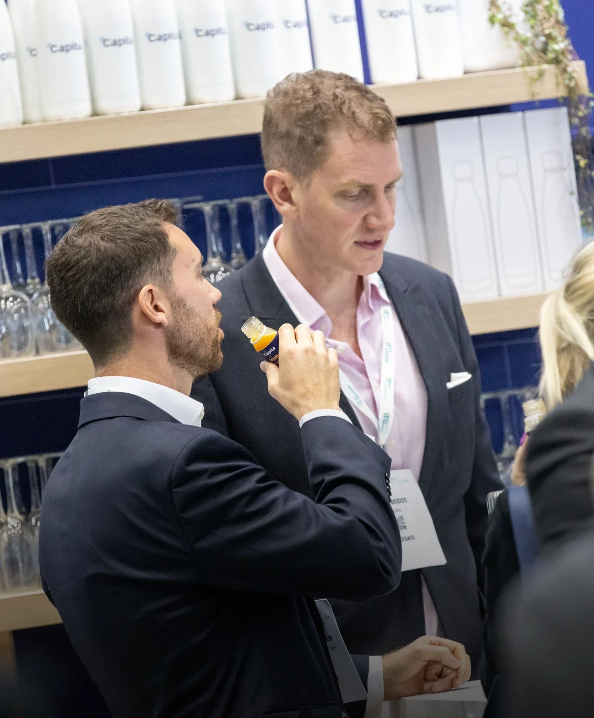 A man about to drink a juice shot at a work event