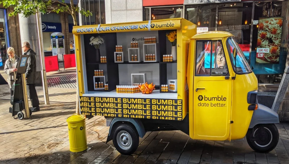 A Bumble branded juice truck in a busy street in Leeds