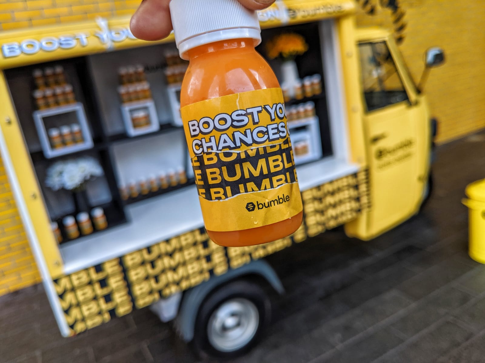 Bumble branded juice shot bottle with orange coloured juice